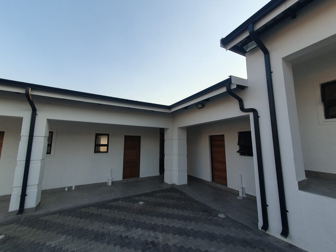 Black box gutter running the full perimeter of a flat roof courtyard building